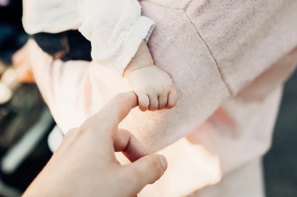 Una bebé sosteniendo el dedo de la mano de una persona. | Foto: Unsplash