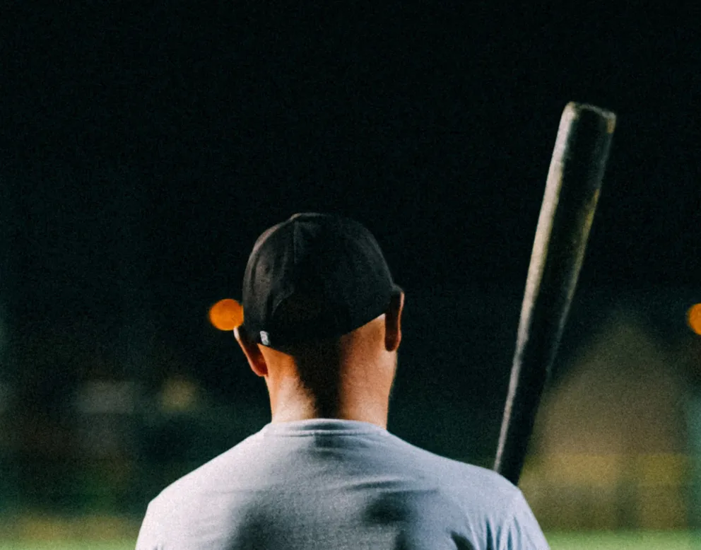 hombre sostiene un bate de béisbol. | Foto: Pexels