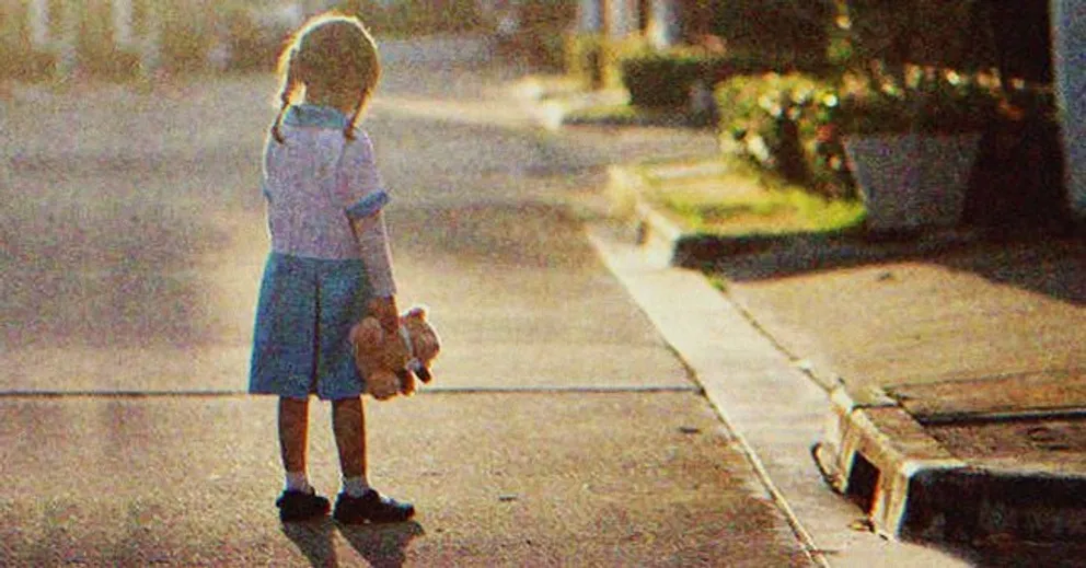 Una niña en medio de una calle sosteniendo un muñeco de felpa. | Foto: Shutterstock