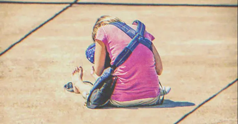Una mujer sin hogar sentada en el suelo con un bebé entre sus brazos. | Foto: Shutterstock