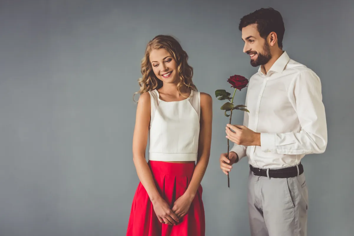 A man gives a girl a red rose. | Photo: Shutterstock
