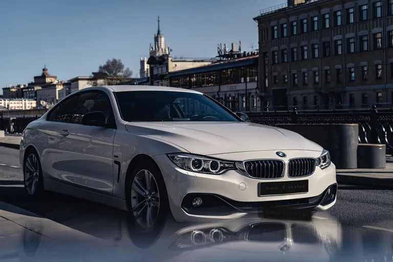 Un automóvil BMW blanco conduciendo a través de una avenida. | Foto: Pexels