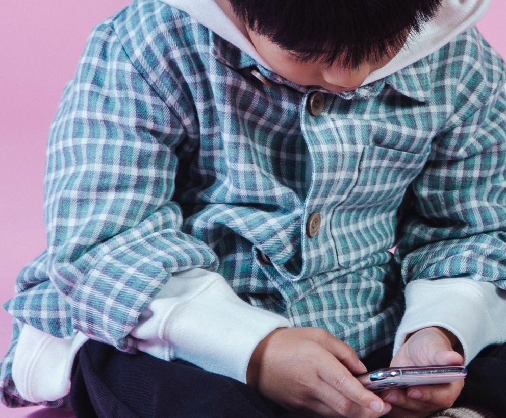 Niño utilizando un teléfono celular. | Foto: Pexels
