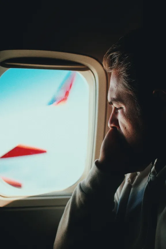 Hombre viendo por la ventana de un avión. | Foto: Unsplash
