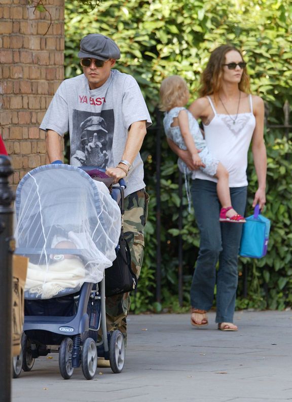 Johnny Depp y Vanessa Paradis con sus dos hijos en un picnic en un parque de Londres el 14 de julio de 2002. | Foto: Getty Images